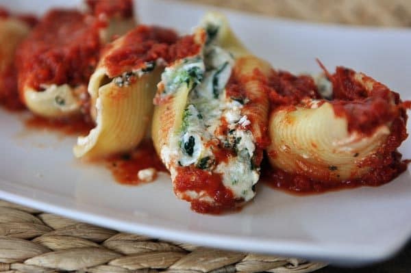 Spinach stuffed jumbo pasta shells covered in a red sauce.