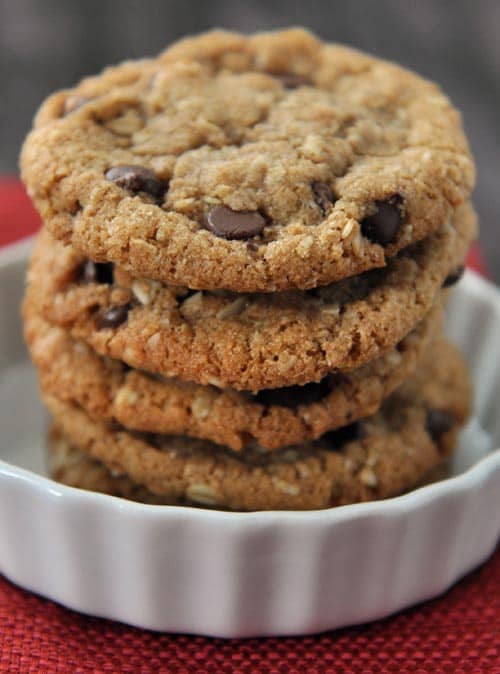 Stacked chocolate chip cookies in a white ramekin.