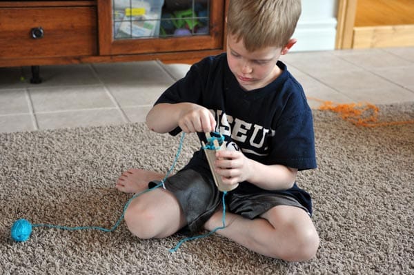 A little boy doing a craft. 