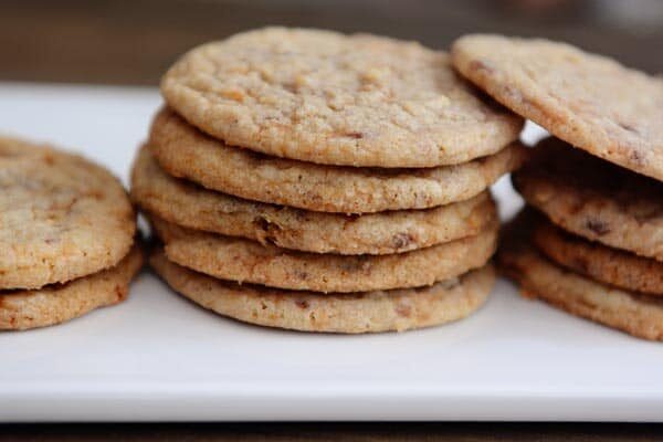 Stacks of thin butterfinger cookies on a white platter.