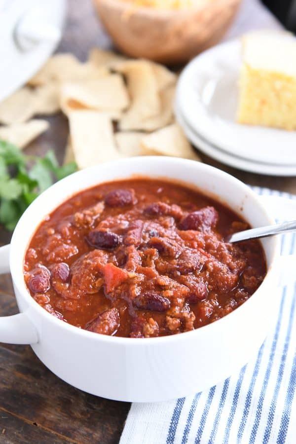 Classic slow cooker chili in white bowl with spoon.
