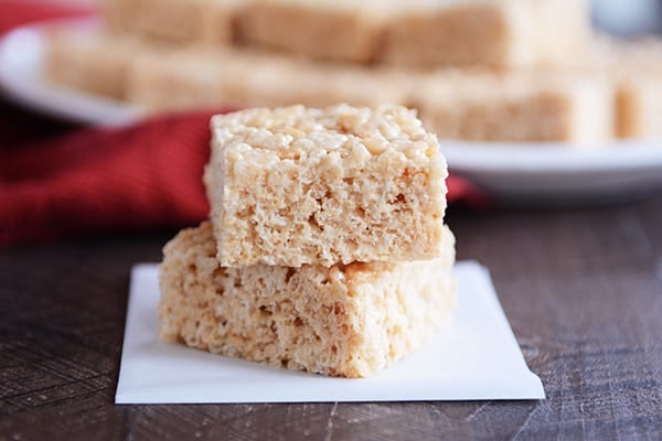 Two rice krispie treats stacked on white parchment.