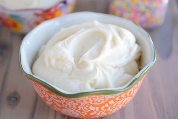 Vanilla buttercream frosting in orange bowl.