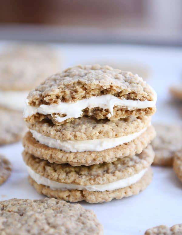 Two homemade oatmeal cream pies stacked on each other with half of a cookie on top.
