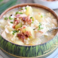 Green bowl filled with pressure cooker chicken corn chowder with bacon on top and spoon in the side.