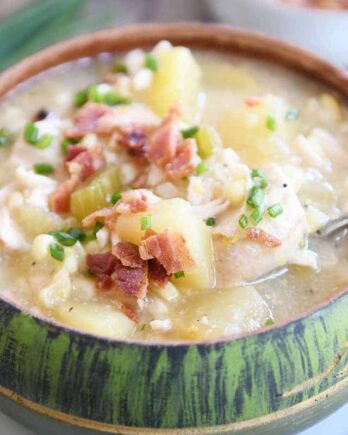 Green bowl filled with pressure cooker chicken corn chowder with bacon on top and spoon in the side.