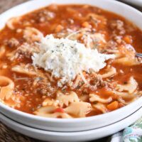 White bowl filled with pressure cooker lasagna soup and dollop of cheesy ricotta mixture.