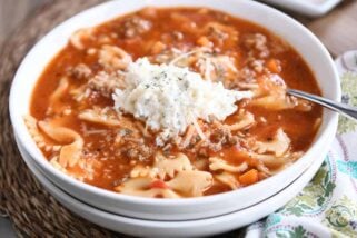 White bowl filled with pressure cooker lasagna soup and dollop of cheesy ricotta mixture.