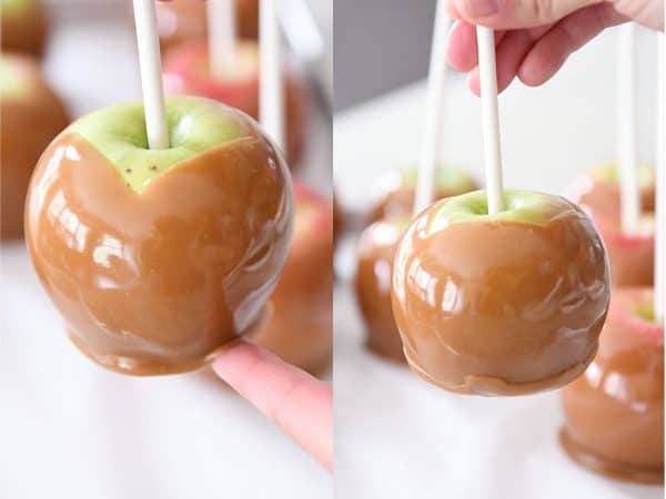 Pressing bottom caramel layer up on homemade caramel apples.