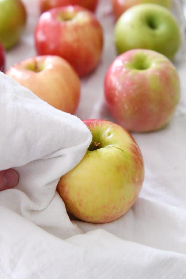 Drying off apples with white cloth.