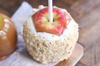 Dipped and decorated homemade caramel apple with white chocolate and graham cracker crumbs.