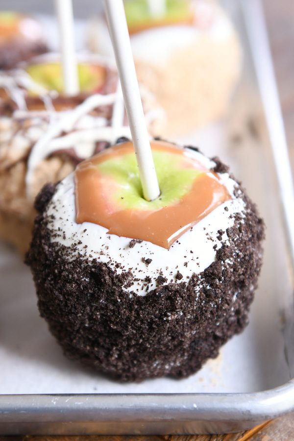 Homemade caramel apple dipped in white chocolate with Oreo crumbs.