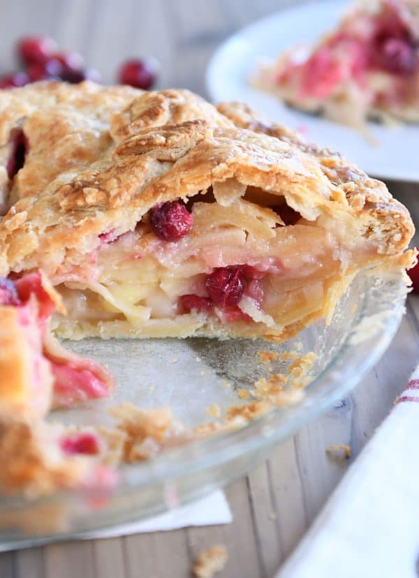 Slice cut out of apple cranberry pie.