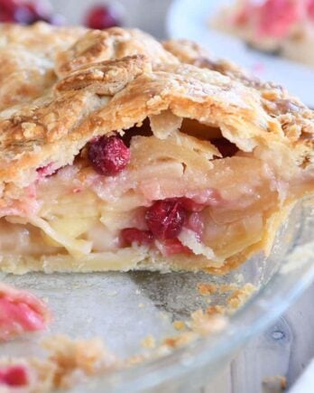 Slice cut out of apple cranberry pie.