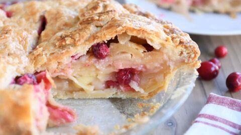 Slice cut out of apple cranberry pie.