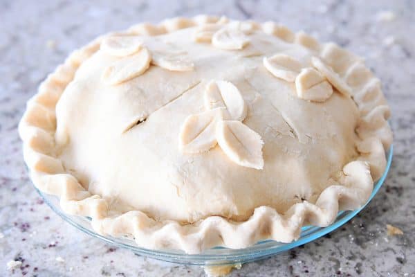 Unbaked apple cranberry pie with top crust and slits in the top.