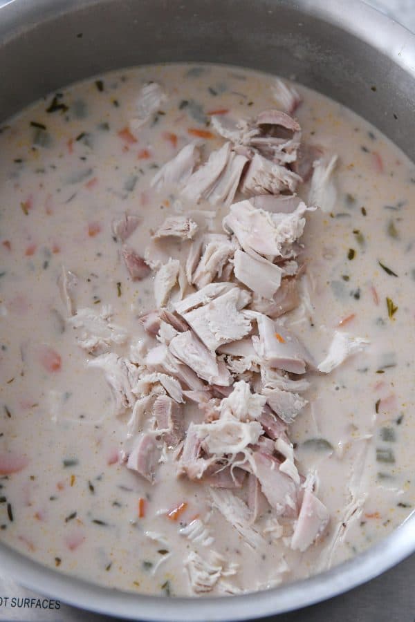Adding turkey to the best leftover turkey soup.