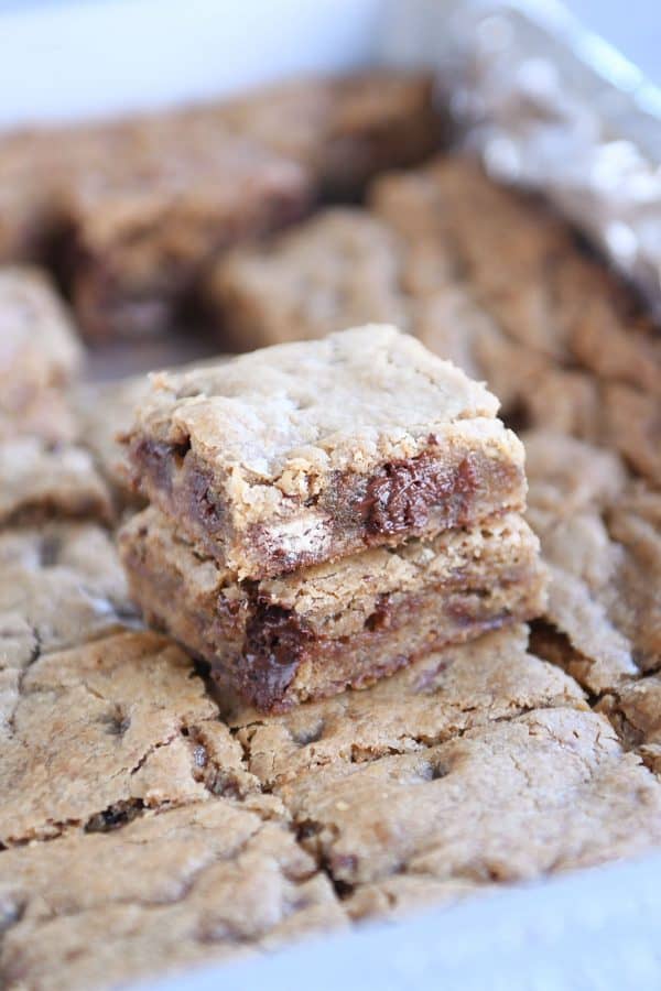 Two malted chocolate chip blondies stacked on each other in pan.