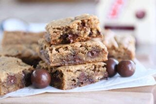 Two malted chocolate chip blondies stacked with half of a blondie on top.