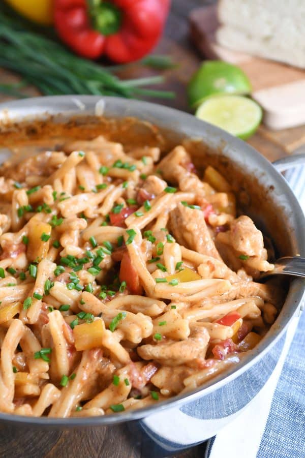 Shallow pan filled with skillet chicken fajita pasta with chives on top.