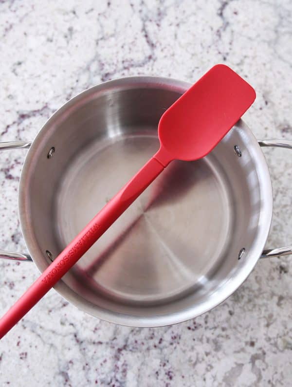 Heavy bottomed pot and red spatula for caramel making.