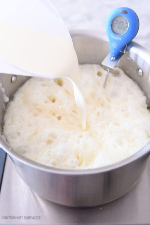 Pouring in warm cream to caramel mixture.