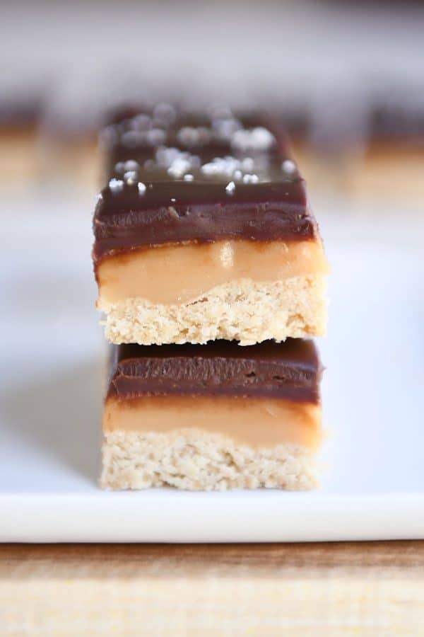 Two homemade grown up Twix bars on white tray.