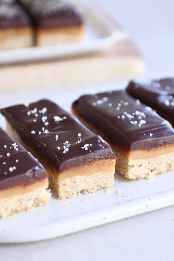 Sliced homemade grown up Twix bars on white tray.