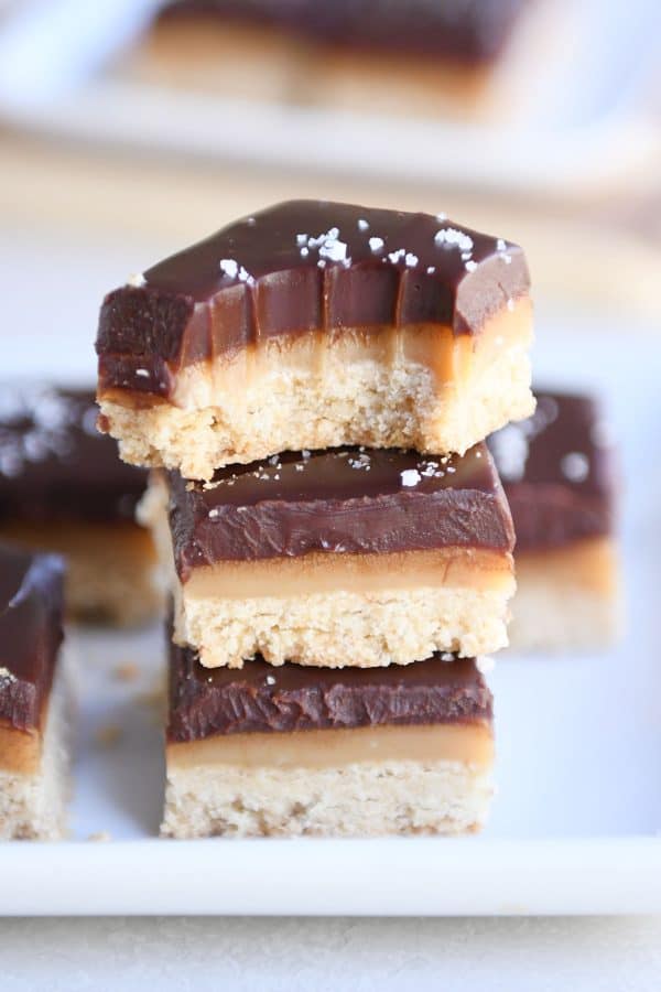 Three homemade grown up Twix bars on each other with bite taken out.