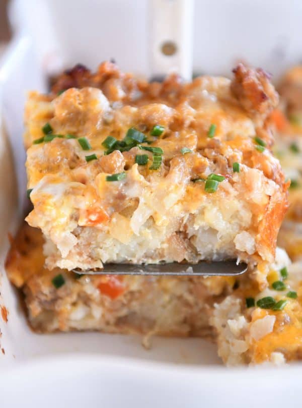 Square of tater tot breakfast casserole scooped on metal spatula.