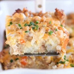 Square of tater tot breakfast casserole scooped on metal spatula.