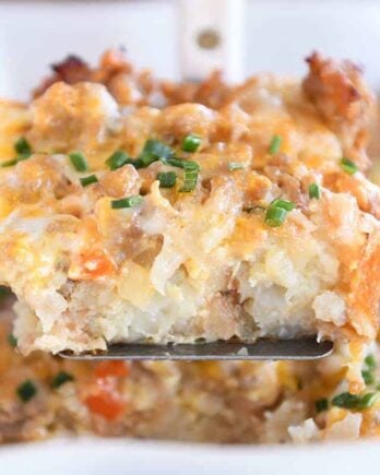 Square of tater tot breakfast casserole scooped on metal spatula.