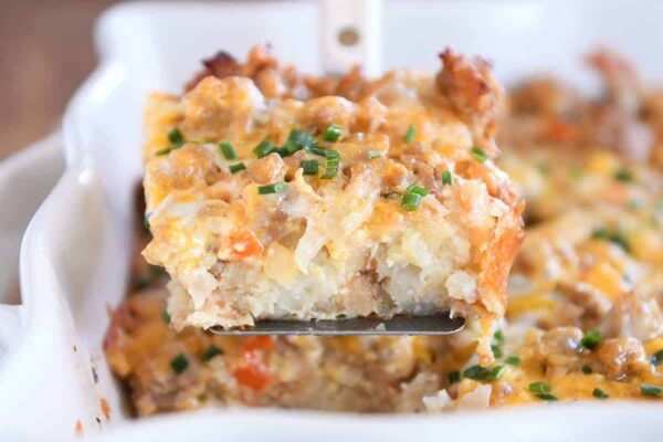 Square of tater tot breakfast casserole scooped on metal spatula.