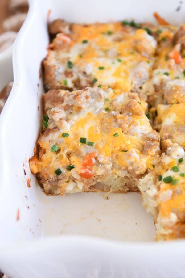 Pan of tater tot breakfast casserole with one piece removed.