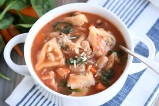 White bowl with handles filled with quick and easy creamy tuscan tortellini soup.