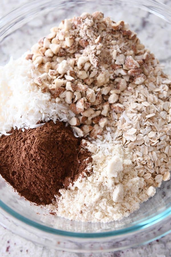 Dry ingredients for dark chocolate brownie granola bars in glass bowl.