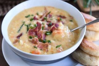 spoon in white bowl filled with cheesy cauliflower soup