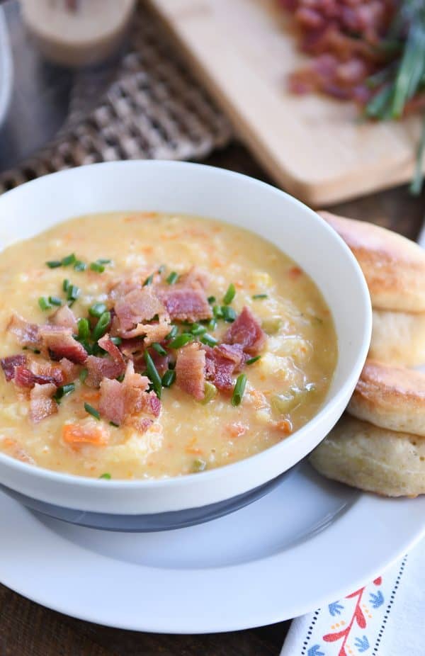 bowl of loaded cheesy cauliflower soup with rolls