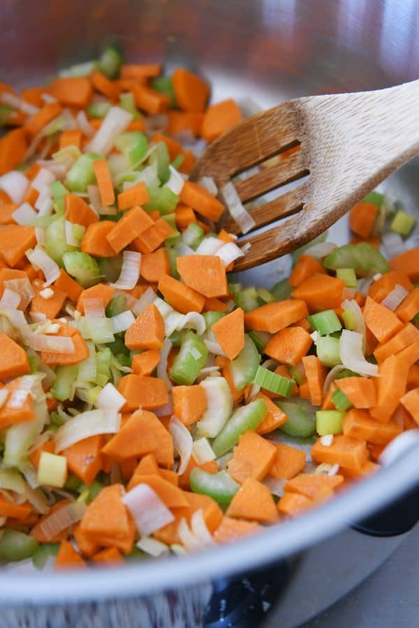 Cooking carrots, onions and celery for cheesy cauliflower soup.