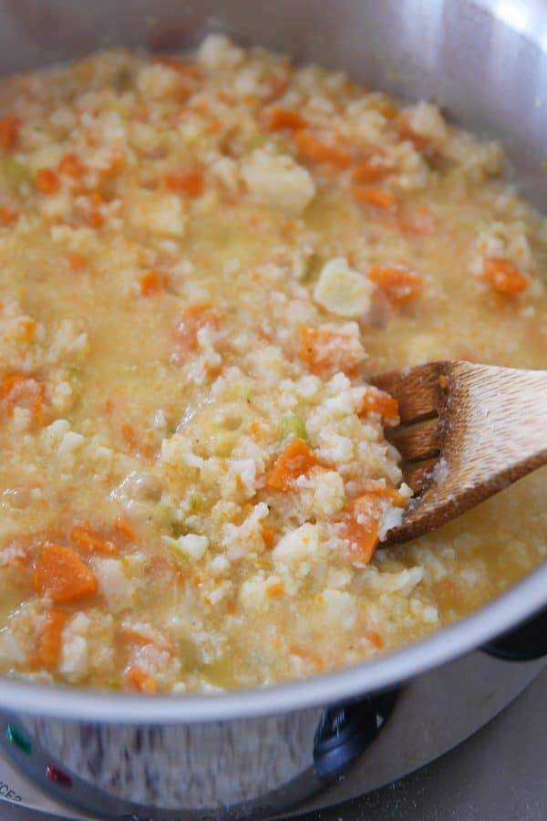 Cooking cheesy cauliflower soup in stainless pot.