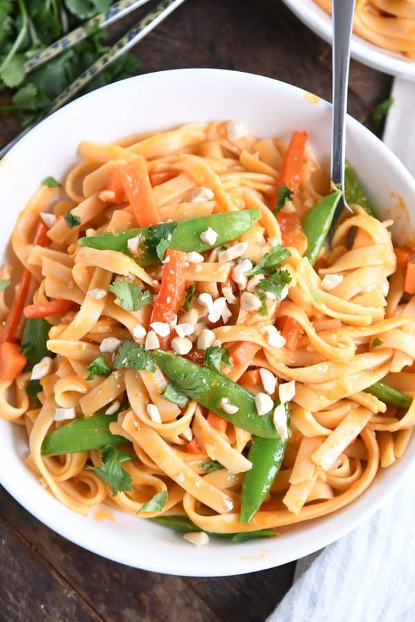 Twirling instant pot red coconut curry noodles with fork.