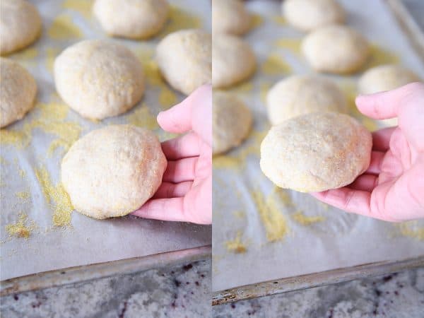 Picking up unbaked english muffins from baking tray.