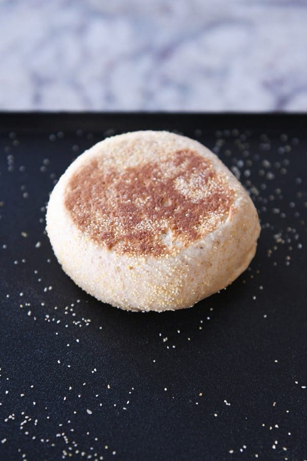 Golden brown homemade English muffin on a griddle. 