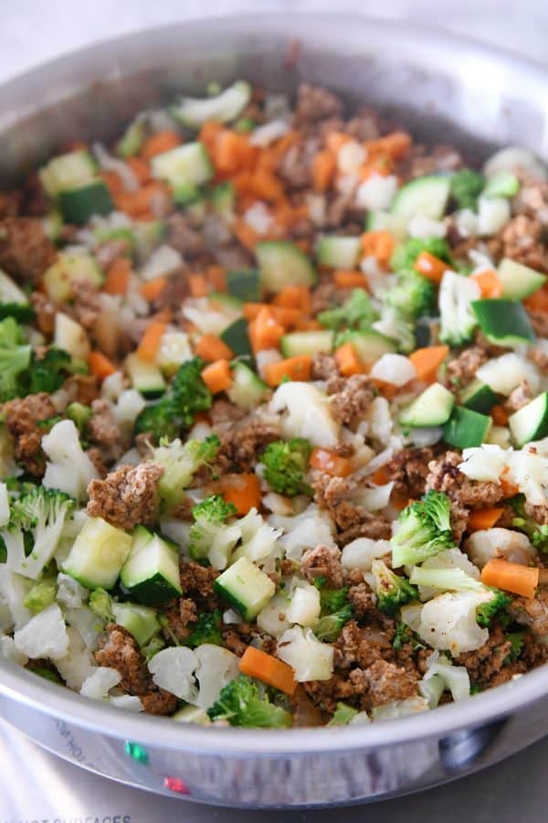 Cooking vegetables and meat for veggie turkey taco lettuce wraps.