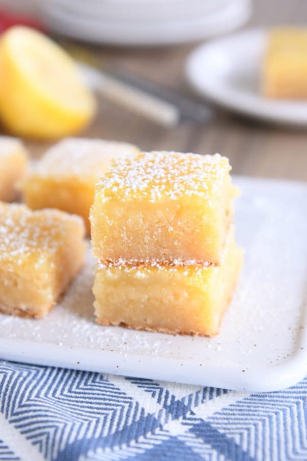 two small squares of lemon bar white chocolate brownies stacked on each other