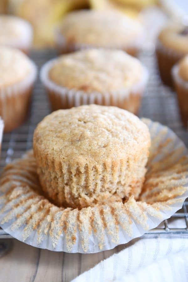 Unwrapped banana muffin on wire rack.