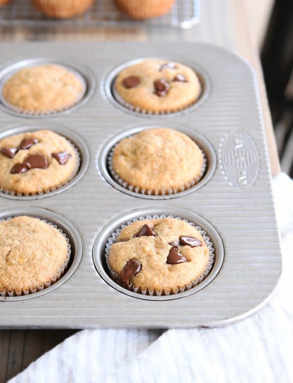 Banana muffins with chocolate chips and without in a muffin tin.