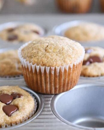 the best banana muffins in muffin tin with one muffin sitting on top