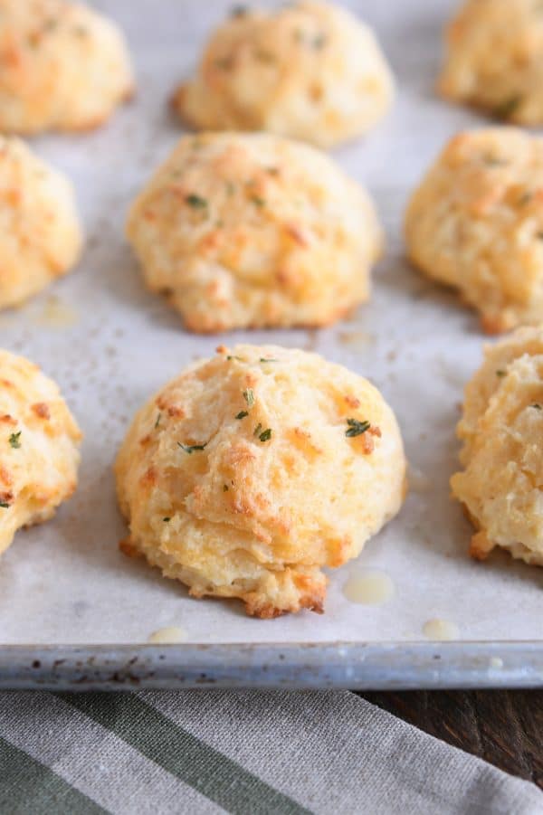 Baked cheesy garlic drop biscuits on parchment lined baking sheet.