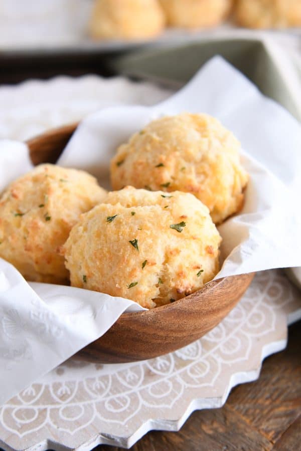 Easy cheesy garlic drop biscuits in wooden bowl with white napkin.